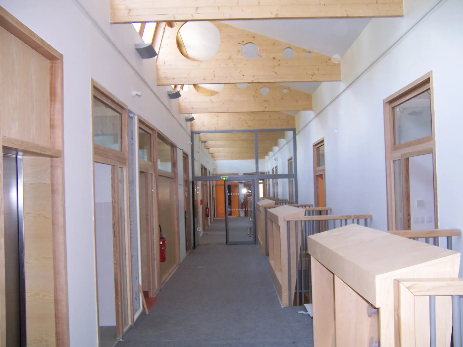 Circulation du groupe scolaire Jules Ferry à Villeurbanne : cloisons et plafonds neufs, charpente en bois clair